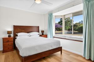 een slaapkamer met een bed en een raam bij Spacious 4-Bed House with Private Garage in Coodanup