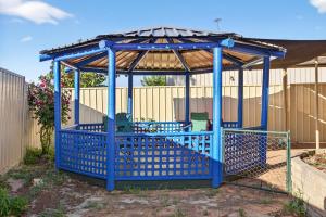 een blauw tuinpaviljoen in een tuin bij Spacious 4-Bed House with Private Garage in Coodanup