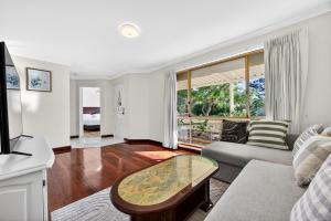 een woonkamer met een bank en een tafel bij Spacious 4-Bed House with Private Garage in Coodanup +48 foto's