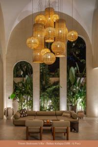 a living room with a couch and chandeliers at Bebas Villas - Uluwatu, Bali in Uluwatu