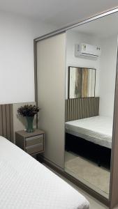 a mirror reflection of a bedroom with a bed at Apartamento Novo in Capão da Canoa +14 photos