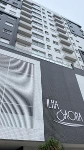 a tall building with a sign on the side of it at Apartamento Novo in Capão da Canoa