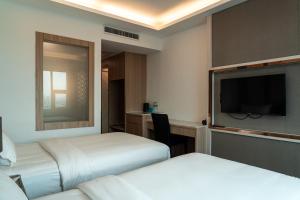 a hotel room with two beds and a flat screen tv at lee hotel lat phrao in Bangkok +13 photos