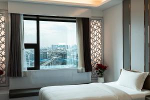 a bedroom with a bed and a large window at lee hotel lat phrao in Bangkok