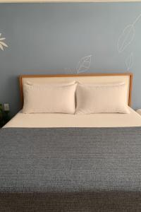 a bed with two pillows on top of it at Estúdio a 1 min do mar - Mila rooftop in Tamandaré +19 photos