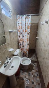 a bathroom with a sink and a toilet and a shower curtain at La Hueya in Coronel Moldes +33 photos