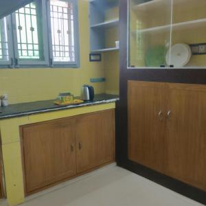 APMSV Home Stay, Lavish 4B Villla في تيروفانمالي: مطبخ مع خزائن خشبية وطاولة عمل