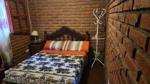 a bedroom with a bed in a brick wall at La Hueya in Coronel Moldes