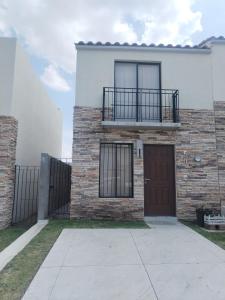 Casa de ladrillo con puerta y balcón en House A in a residential condominium with a pool, en Miranda