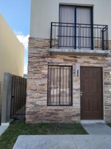 Un edificio con una puerta marrón y un balcón. en House A in a residential condominium with a pool, en Miranda