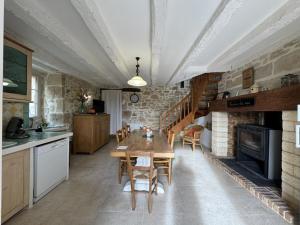 Gîte rustique avec piscine privée et Wifi - FR-1-616-70 في Cherveix-Cubas: مطبخ وغرفة طعام مع طاولة وكراسي