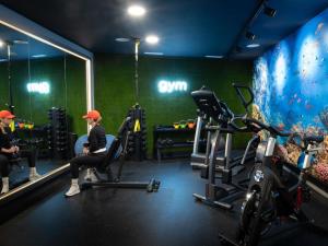 a gym with a woman sitting in a chair in a gym at ibis Styles Santander in Santander