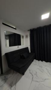 a living room with a black couch and a mirror at Departamento Pavones Beach Retreat in Pavones +12 photos