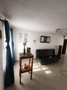 ビージャ・デ・レイバにあるRoomiie Hostelの黒いソファとテーブルのあるリビングルーム +36枚の写真