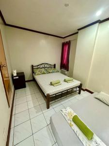 ein kleines Schlafzimmer mit zwei Betten und einem Fenster in der Unterkunft Cranberry's 3 br Apartment nr Convention Ctr #4 in Iloilo City + 11 Fotos
