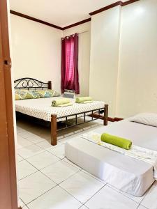 ein Zimmer mit zwei Betten und einem roten Fenster in der Unterkunft Cranberry's 3 br Apartment nr Convention Ctr #4 in Iloilo City