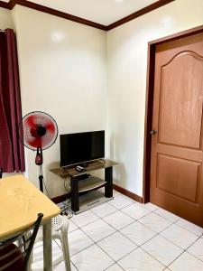 Zimmer mit einem TV und einem Tisch mit einem Ventilator. in der Unterkunft Cranberry's 3 br Apartment nr Convention Ctr #4 in Iloilo City