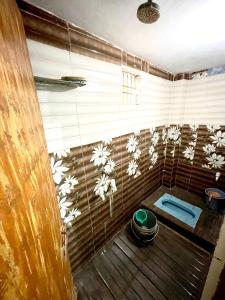 a bathroom with a shower with flowers on the wall at Bajrang kutir 17 in Varanasi