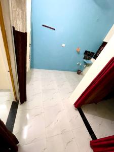 a room with a blue wall and a tile floor at Bajrang kutir 17 in Varanasi
