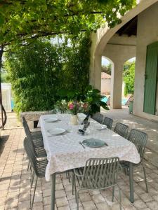 un tavolo con sedie e una tovaglia su un patio di Casa Limonella - Maison 12 pers avec piscine a Fontvieille