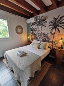 COTTAGE BLUE classé 3 étoiles - 4 à 6 personnes - 2 chambres - accès direct à la plage et à l'esplanade de Boucan Canot avec ses bars et restaurants في سان جيل لي بان: غرفة نوم عليها سرير وفوط