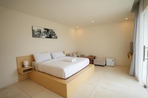 a bedroom with a white bed and a window at Volcano Bliss Villa Kintamani in Kintamani