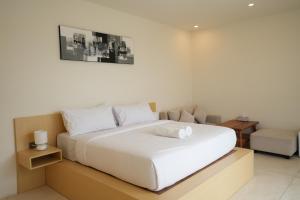 a bedroom with a large white bed and a chair at Volcano Bliss in Kintamani