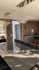 een eetkamer met een tafel en een kroonluchter bij Apto elegante no Catolé 301 in Campina Grande