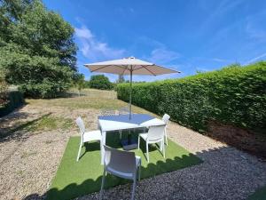 a white table and chairs with an umbrella at Gîte de Charme avec Jardin, Wifi et Parking à Saint-Gourson - FR-1-653-285 in Saint-Gourson