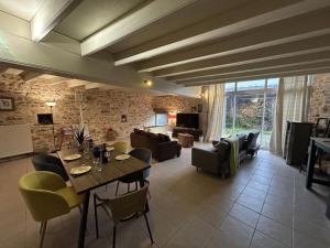 a large living room with a table and chairs at Gîte de Charme avec Jardin, Wifi et Parking à Saint-Gourson - FR-1-653-285 in Saint-Gourson