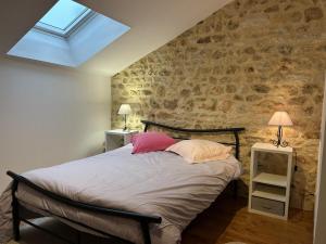 a bedroom with a bed with two pillows on it at Gîte de Charme avec Jardin, Wifi et Parking à Saint-Gourson - FR-1-653-285 in Saint-Gourson