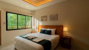 a bedroom with a bed with two towels on it at Dono Pool Villa & Spa in Dauis