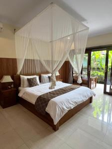 - une chambre avec un grand lit et des moustiquaires dans l'établissement Eka Bali Guest House, à Ubud