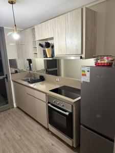 a kitchen with a stove top oven next to a refrigerator at Departamento con vista a coquimbo y bahía in Coquimbo