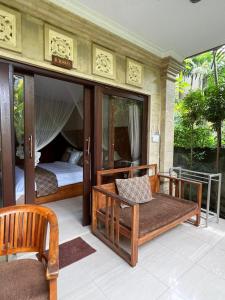 Cette chambre comprend un lit, un lit et un canapé. dans l'établissement Eka Bali Guest House, à Ubud