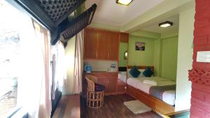 a bedroom with a bed and a chair in it at Tranquil Haven with shared kitchen access at greentara heritage home in Pātan