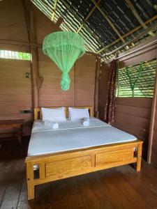 uma cama em um quarto com um lustre verde em LakeSide Cabana Tissamaharama em Tissamaharama