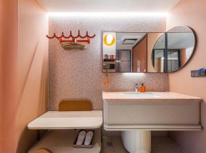 ein Badezimmer mit Waschbecken und Spiegel in der Unterkunft Orange Hotel Suzhou Shishan Financial Innovation Center in Suzhou