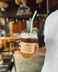 a person holding a cup of coffee with a straw at บ้านฤดี - Baanruedee Kohkood in Ko Kood +11 photos