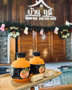 two bottles of orange juice sitting on top of a counter at บ้านฤดี - Baanruedee Kohkood in Ko Kood