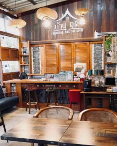 ein Restaurant mit Holzwänden und Tischen und Stühlen in der Unterkunft บ้านฤดี - Baanruedee Kohkood in Ko Kood