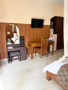 - une chambre avec un bureau et une table avec un miroir dans l'établissement Eka Bali Guest House, à Ubud