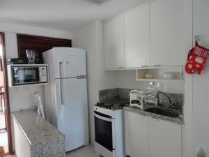 eine Küche mit weißen Schränken und einem weißen Kühlschrank in der Unterkunft Nannai residence Flat 202 in Porto De Galinhas