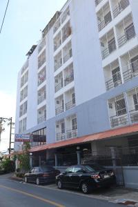 two cars parked in front of a large white building at DD House Apartment in Bangkok +8 photos