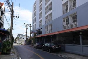 a street with two cars parked in front of a building at DD House Apartment in Bangkok
