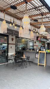 Talya Patong Hotel في شاطيء باتونغ: مطعم به طاولات وكراسي وثريات