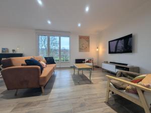 a living room with a couch and a flat screen tv at Les champs dessus in Sarrey