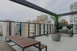 einen Balkon mit einem Tisch und einer Topfpflanze in der Unterkunft Essenza Elysia Premium Studio in Curitiba + 6 Fotos