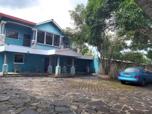 Ahuachapán Getaway : بيت ازرق فيه سياره متوقفه امامه