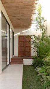 a house with a wooden door and some plants at Casa Amani 3BR Mediterranean w Pool Near Seminyak in Kerobokan